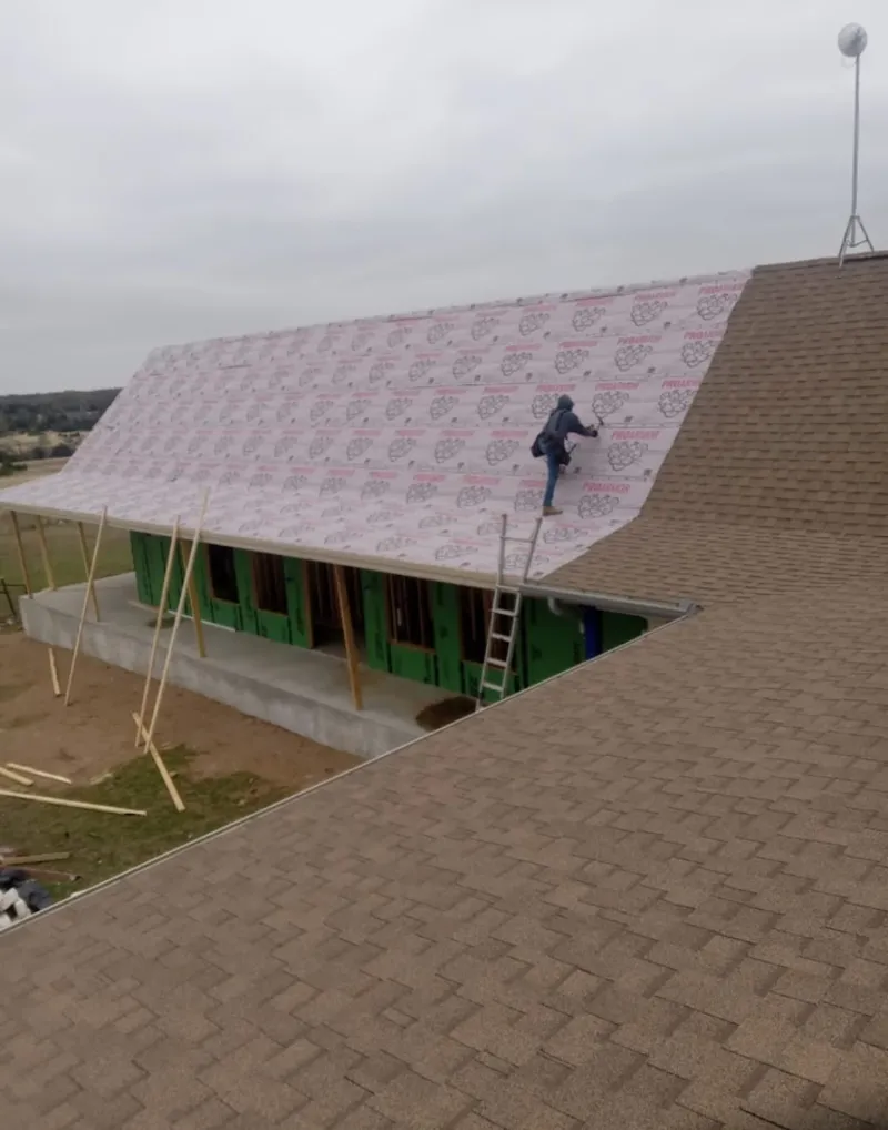 Worker preparing underlayment for a metal roof installation in Shiloh